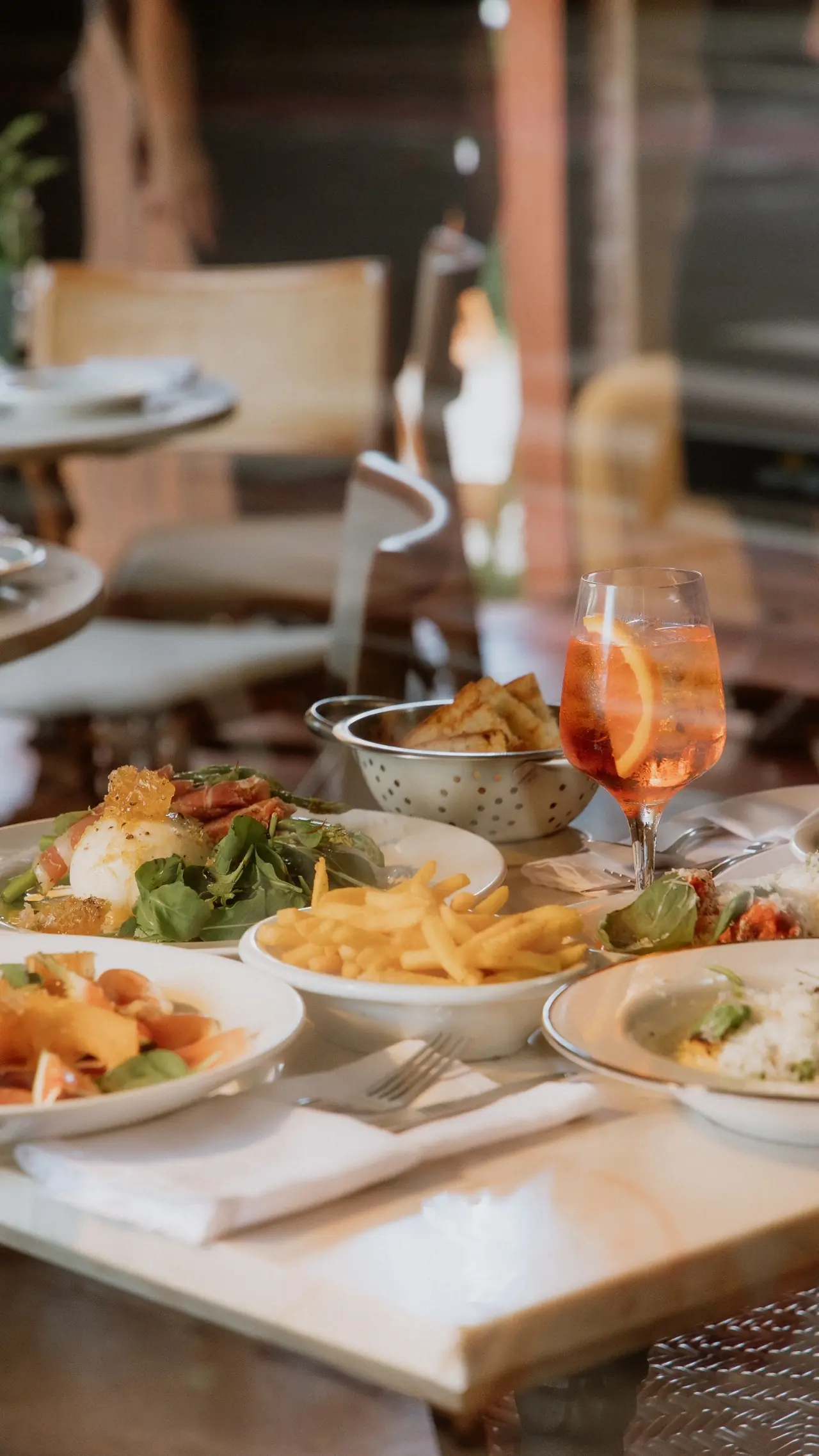Mesa farta com vários pratos italianos e drinks vistos de cima